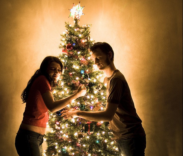 couple lovingly hugging a christmas tree
